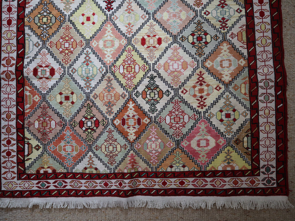 Detail of upper border with chain-link pattern and diamond motifs in natural dyes